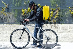 Delivery man on bike looking at smartphone